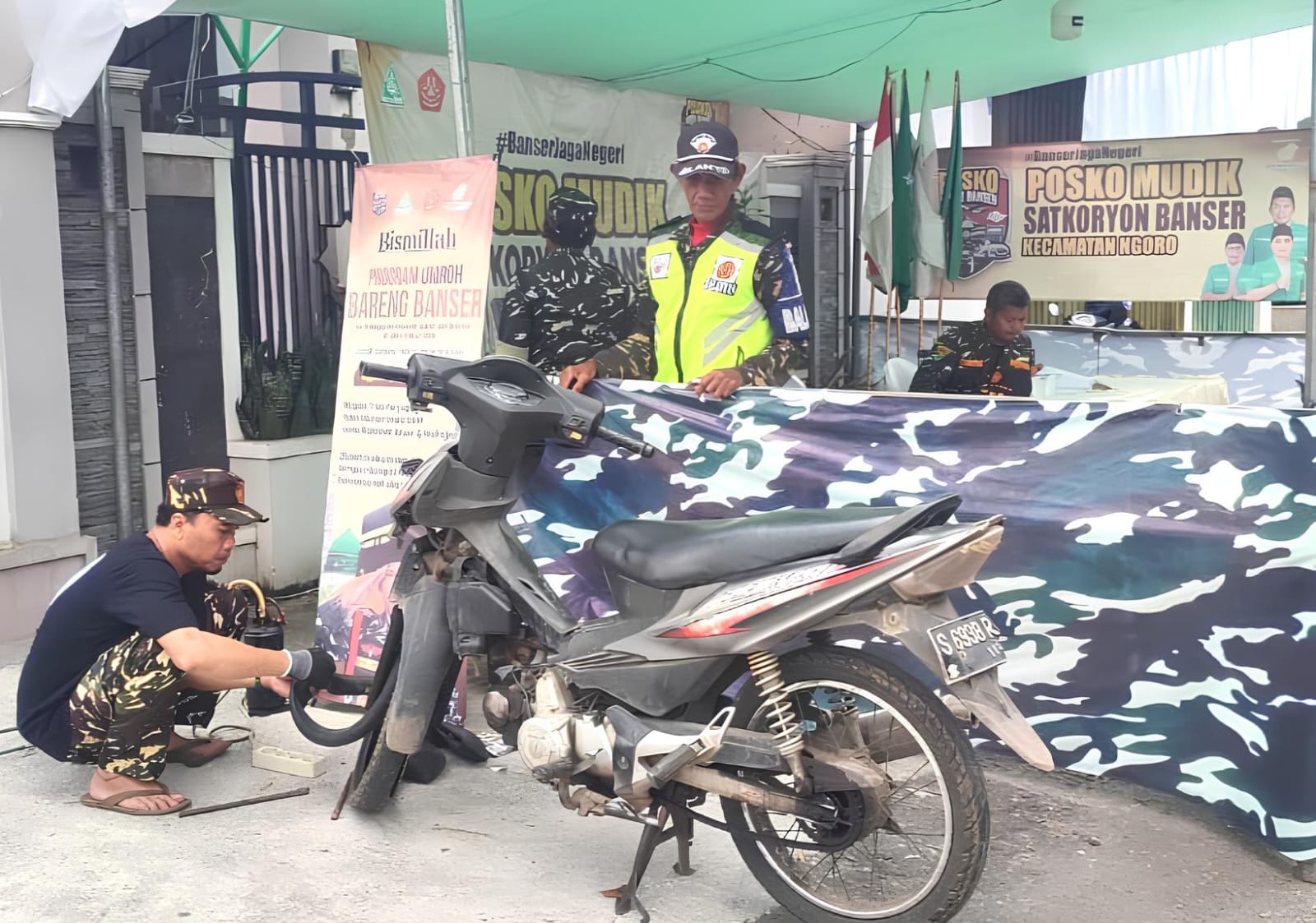 Anggota Banser dengan Sigap Menambal Ban Pemudik Yang Bocor